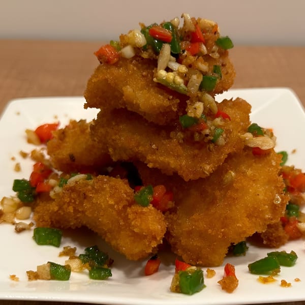 Golden-fried Chinese fish fillets topped with diced red and green peppers and garlic.